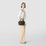 SMALL MARO BAG IN CACHEMIRE LEATHER AND MOSAICO, worn on the shoulder; side view of a woman in a light blouse against a neutral background.