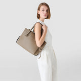 Side view: Model wears MEDIUM MARO BAG IN CACHEMIRE LEATHER AND MOSAICO over her shoulder; Sahara Mosaico, supple Cachemire leather, side knots and textured surface.