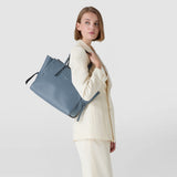 Frontal view: MEDIUM MARO BAG IN CACHEMIRE LEATHER AND MOSAICO is worn over the shoulder of a woman in a cream pantsuit, neutral light background.