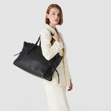 Frontal view — Model wears the MAXI MARO BAG IN CACHEMIRE LEATHER AND MOSAICO over her shoulder, a large black tote with a Mosaico insert at the top and knotted nappa leather strips at the sides, against a neutral background.