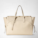 Frontal view: MAXI MARO BAG IN CACHEMIRE LEATHER AND MOSAICO shows a cream-colored, roomy tote bag with Mosaico weave, knotted nappa leather strips at the sides, two handles and an adjustable shoulder strap. Text: SERAPIAN
