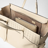 Front view: MAXI MARO BAG IN CACHEMIRE LEATHER AND MOSAICO shows an open cream tote bag revealing interior compartments and the Mosaico weave with a knotted nappa leather strip, against a light neutral background.