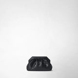 Front view: MINI SECRET CLUTCH BAG IN MOSAICO is centered against a light studio background; the compact black leather clutch features a distinctive angular clasp and a glossy woven Mosaico pattern.