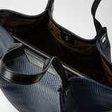 Front view of the VERTICAL SECRET TOTE BAG IN STEPAN shows an open, ocean blue tote bag with black leather, textured pattern, zipper, and multiple compartments.